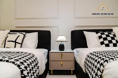 two beds with black and white covers and a lamp on a night stand at Georgetown Elegant Chanel-style KTV 4BR 18Pax A in George Town