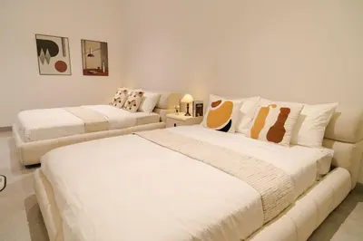 two beds in a room with white walls at Georgetown Bright & Kid-Friendly KTV 3BR 15pax C in George Town