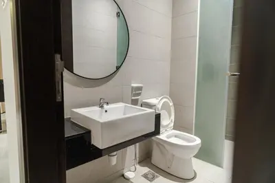 a bathroom with a sink and a toilet and a mirror at Georgetown Stylish Design Jacuzzi KTV 5BR 16pax D in George Town