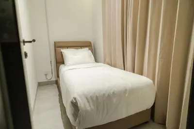a small bedroom with a bed with white sheets at Georgetown Stylish Design Jacuzzi KTV 5BR 16pax D in George Town