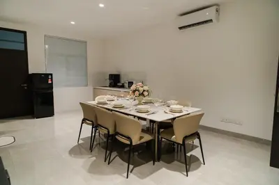 a dining room with a table and chairs and a kitchen at Georgetown Stylish Design Jacuzzi KTV 5BR 16pax D in George Town