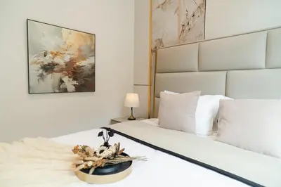 a bedroom with a white bed and a painting at Georgetown Elegant Golden Jacuzzi KTV 5BR 16pax E in George Town