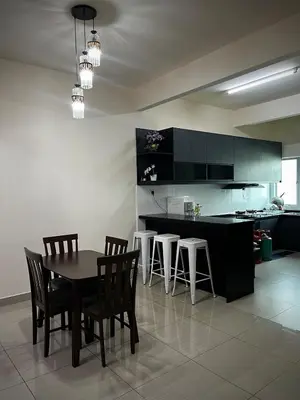 a kitchen with a table and chairs and a counter at Homestay Adyana in Raub