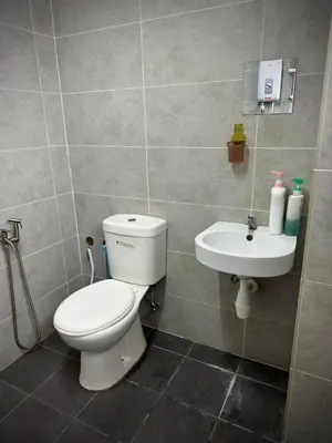 a bathroom with a toilet and a sink at Homestay Adyana in Raub