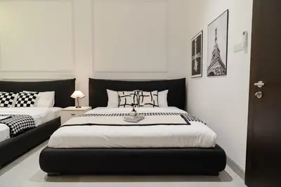 a bedroom with two beds with black and white at Georgetown Chanel-Style Jacuzzi & KTV 5BR 18pax F in George Town