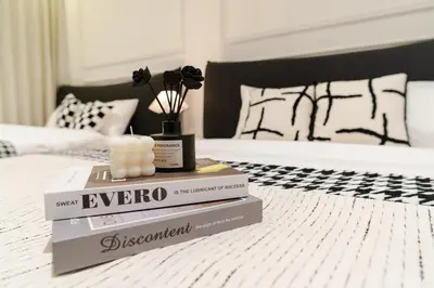 two books on a bed with a vase on top at Georgetown Chanel-Style Jacuzzi & KTV 5BR 18pax F in George Town