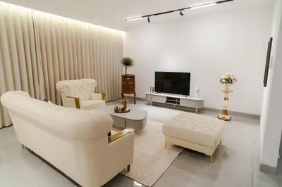 a living room with white furniture and a television at Georgetown Italian-Style Jacuzzi KTV 5BR 18pax G in George Town
