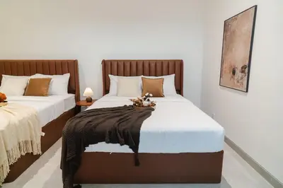 a bedroom with two beds with white and brown pillows at Georgetown Modern Brown-Colored KTV 5BR 18pax H in George Town