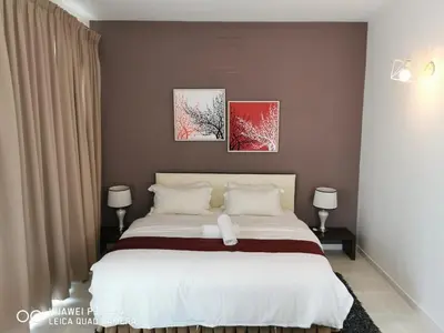 a bedroom with a bed with two pictures on the wall at 2 Spacious Lupsxury conor villa garden Parking group family gathering wedding in Gelugor