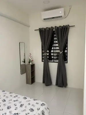 a bedroom with a bed with black curtains and a mirror at Aleesa Homestay in Tapah