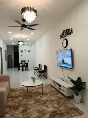 a living room with a couch and a tv on a wall at Aleesa Homestay in Tapah