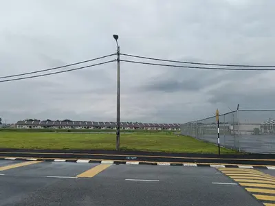 an empty street with a light pole and a field at Aleesa Homestay in Tapah