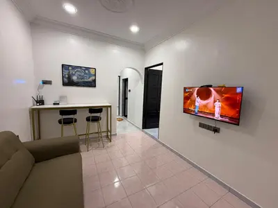 a living room with a couch and a tv on a wall at raub homesty in Raub