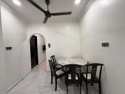 a table and chairs in a room with a ceiling fan at raub homesty in Raub