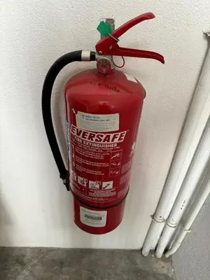 a fire extinguisher is attached to a wall at Spacious 4BR Family Suites in George Town in George Town