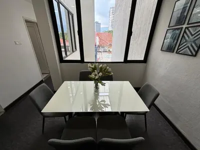 a white table and chairs in a room with a window at Spacious 4BR Family Suites in George Town in George Town