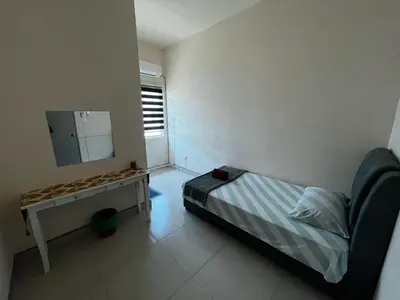 a small bedroom with a bed and a mirror at Homestay Adyana in Raub