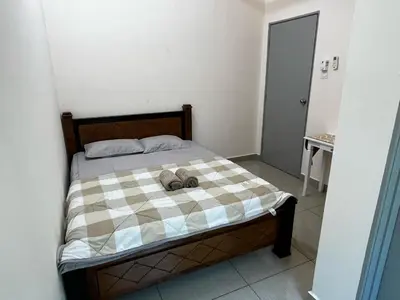 a bedroom with a bed with two shoes on it at Homestay Adyana in Raub