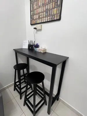 a black table with two stools next to a wall at Raub homesty in Raub