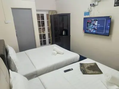 a hotel room with two beds and a tv at Cool view hotel in Tanah Rata