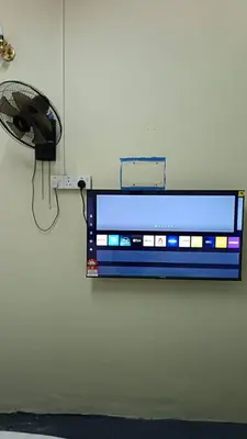 a television hanging on a wall with a fan at Cool view hotel in Tanah Rata