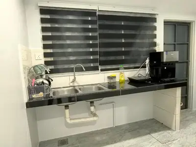 a kitchen counter with a sink and a microwave at 32 Homestay in Teluk Intan