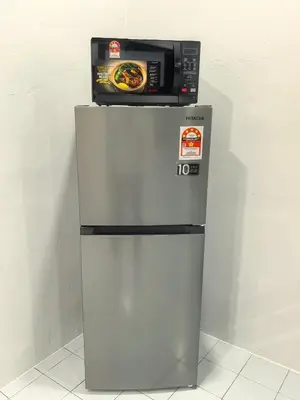 a microwave sitting on top of a refrigerator at 32 Homestay in Teluk Intan