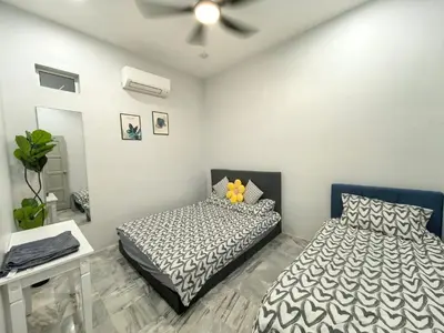 a bedroom with two beds and a ceiling fan at 32 Homestay in Teluk Intan