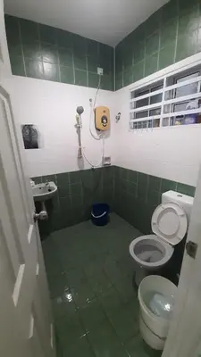 a green tiled bathroom with a toilet and a sink at Glory Homestay Ipoh in Ipoh