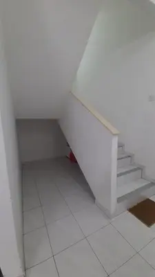 a staircase in a white room with white tile floors at Glory Homestay Ipoh in Ipoh