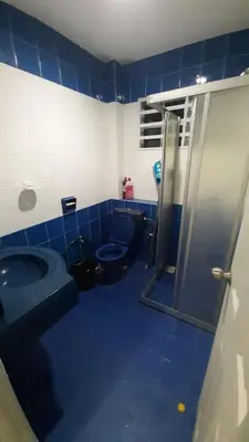 a blue bathroom with a toilet and a shower at Glory Homestay Ipoh in Ipoh