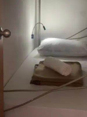 a white bed with a towel on a table at Heritage House 123 in George Town