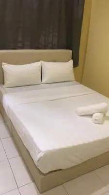 a large white bed with white sheets and pillows at Dynamic homes stay in Ipoh