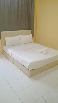 a bed with white sheets and pillows in a room at Dynamic homes stay in Ipoh