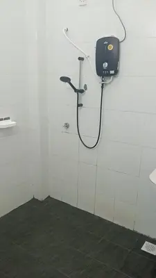 a shower in a white room with a phone on the wall at Dynamic homes stay in Ipoh