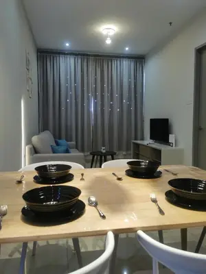 a wooden table with plates and spoons on top of it at Iconic Regency Service Residences - Xin's Home in Bayan Lepas