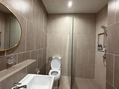 a bathroom with a toilet and a sink and a mirror at Iconic Regency Service Residences - Xin's Home in Bayan Lepas
