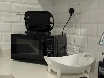 a white bowl sitting next to a microwave at Iconic Regency Service Residences - Xin's Home in Bayan Lepas