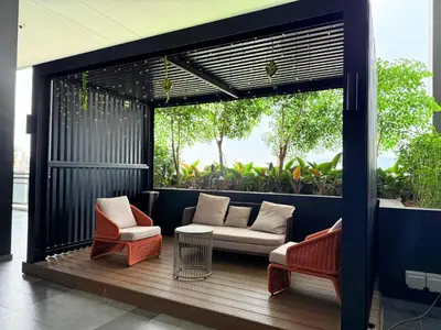 a patio with two chairs and a couch on a deck at Iconic Regency Service Residences - Xin's Home in Bayan Lepas