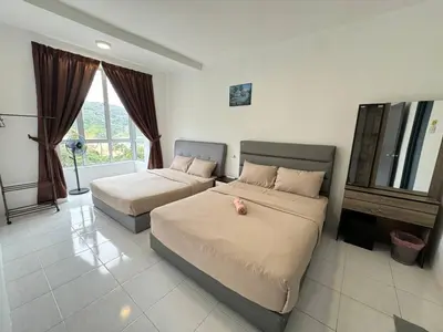 a bedroom with two beds and a dresser at Eisya Homestay 2 at Emerald Avenue Brinchang in Brinchang