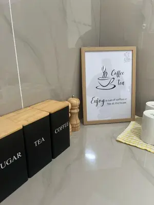 a table with three black boxes and a picture at Villa Alyana in Ipoh