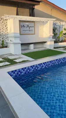 a swimming pool in front of a building at Villa Alyana in Ipoh