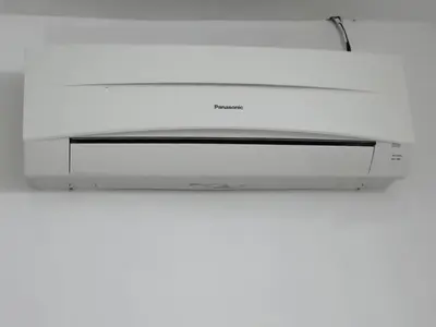 a white microwave oven hanging from a white wall at Rasa Motel in Batu Ferringhi