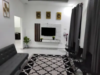 a living room with a couch and a television at Tasmie homestay in Butterworth