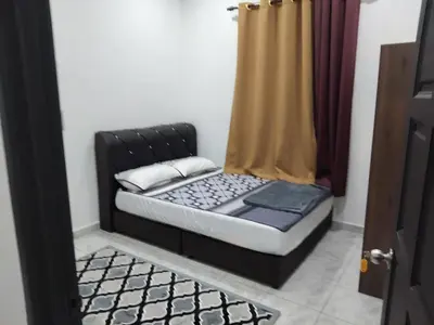 a small bed in a room with a curtain at Tasmie homestay in Butterworth