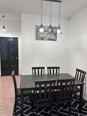 a dining room with a black table and chairs at Rafeeqs Homestay in Teluk Intan