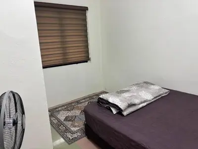 a bedroom with a bed and a window with a pillow at Rafeeqs Homestay in Teluk Intan