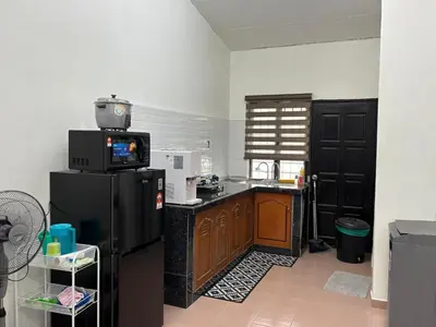 a kitchen with a black refrigerator and a microwave at Rafeeqs Homestay in Teluk Intan