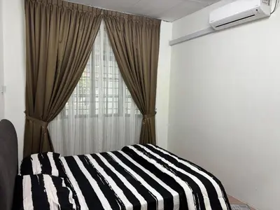 a bedroom with a black and white striped bed and a window at Rafeeqs Homestay in Teluk Intan