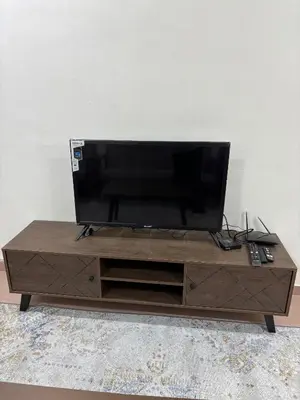 a wooden entertainment center with a flat screen tv on it at Rafeeqs Homestay in Teluk Intan